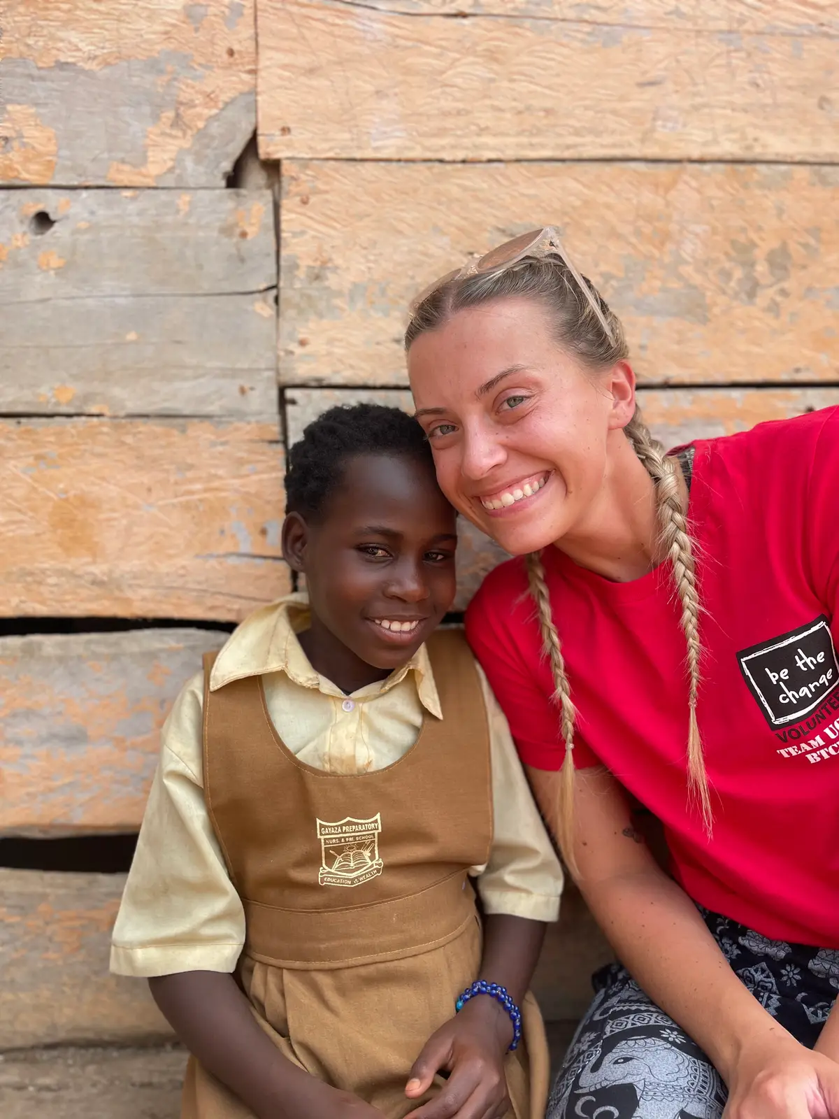 A BTCV Kid in her school uniform smiling beside a BTCV volunteer