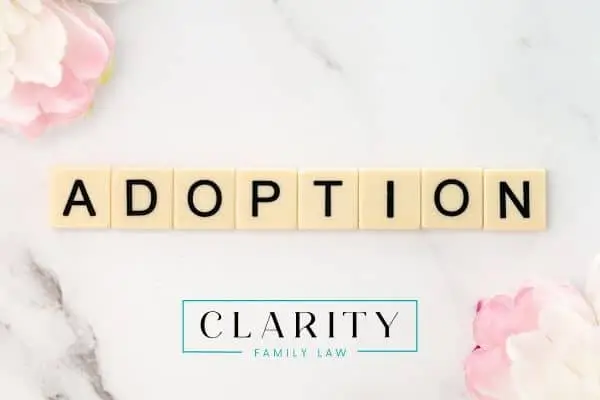 the word adoption spelled in tiles next to some flowers