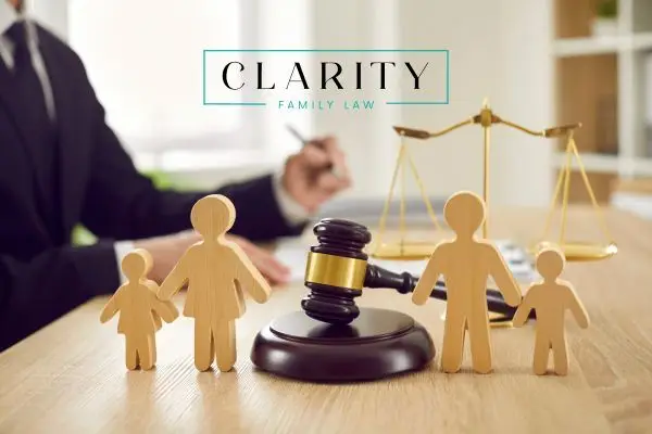 a wooden block family on a desk next to a lawyer, gavel, and scale