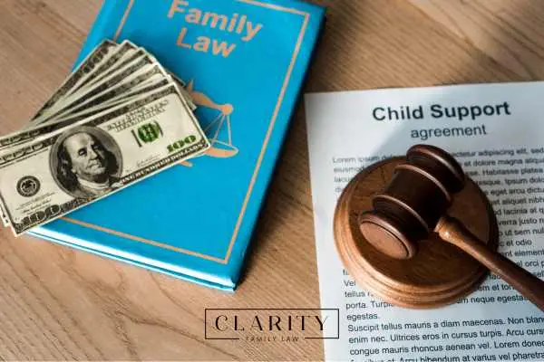 a legal book, money, child support agreement, and gavel on a desk