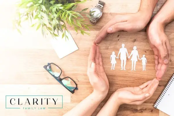 a couple forming a circle with their hands around a cutout family