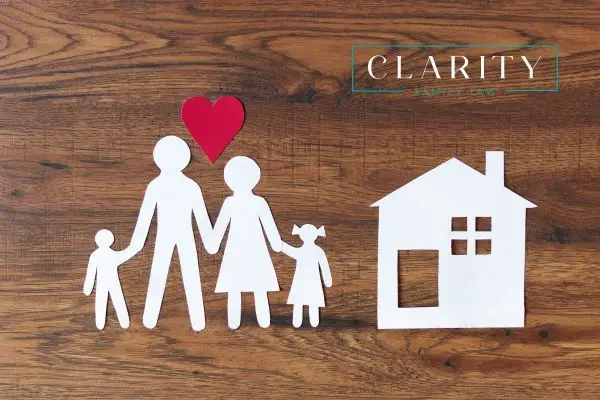 a paper cutout of a family next to a house