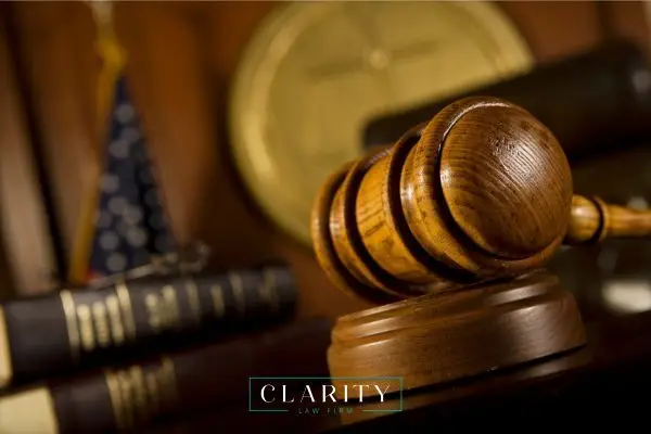a photo of a gavel and law books on a judge's bench in a court room