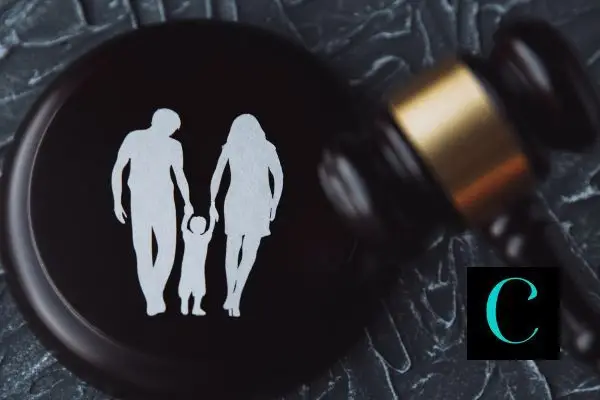 a paper cutout of a family on top of a gavel with the hammer next to it