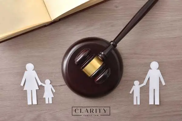 a gavel and cutout of a family on a wooden desk