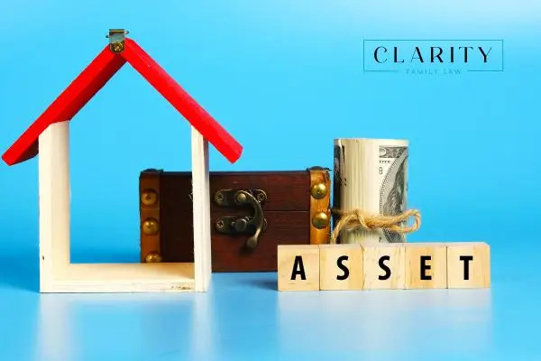Small wooden house, chest, and cash with the word assets written in front