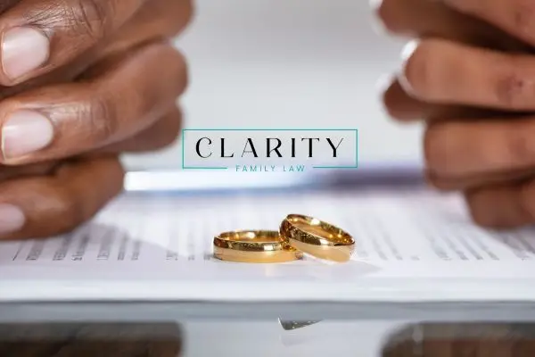 Hands over divorce papers with wedding rings