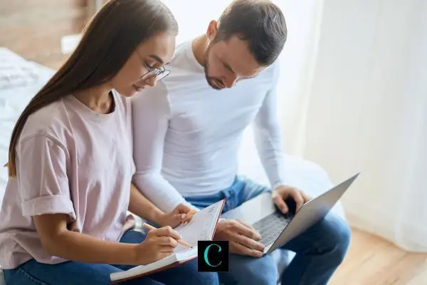 A couple reviewing documents and a laptop.