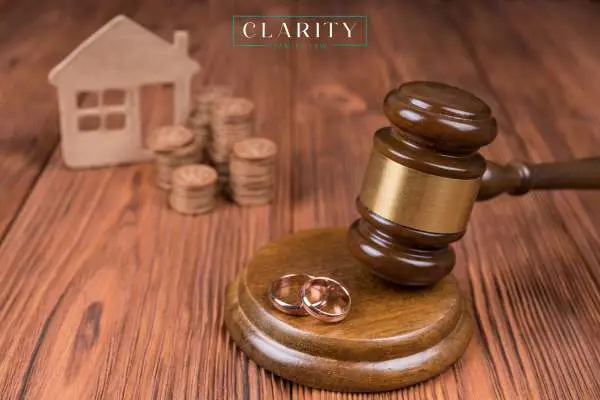a gavel, 2 wedding rings, and a model home on a desk