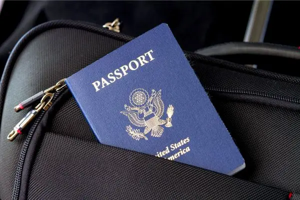 US Passport poking out of a black backpack