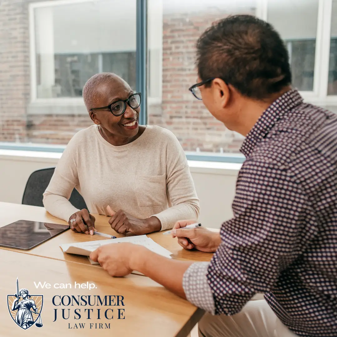 A client works with an attorney in a conference room. The attorney is helping his client with her HireRight background check errors.