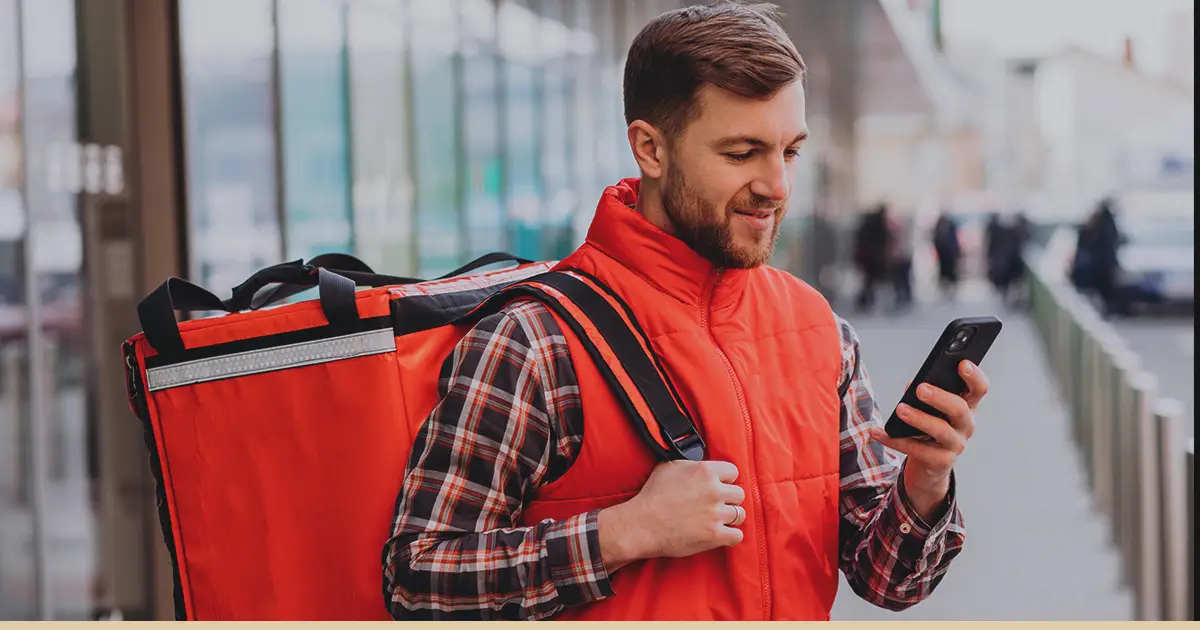 A DoorDash driver checks his app before delivery.