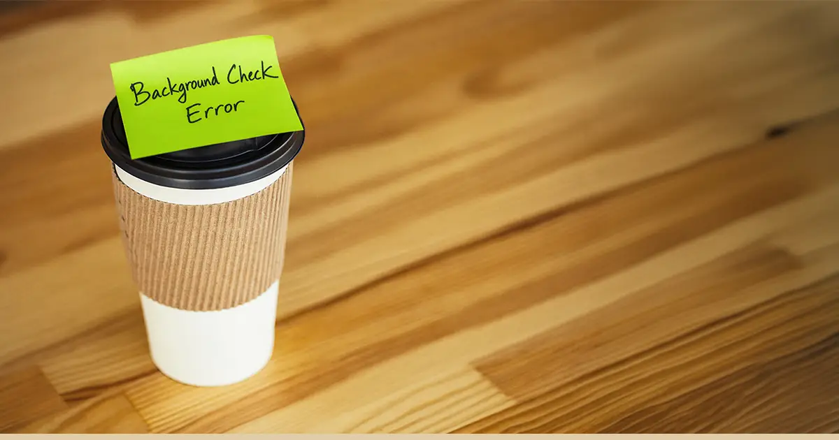 A coffee cup with a reminder about a background check