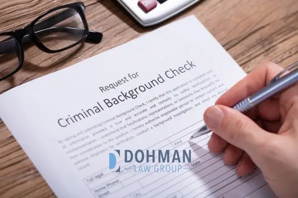 A person filling out a criminal background check request form.
