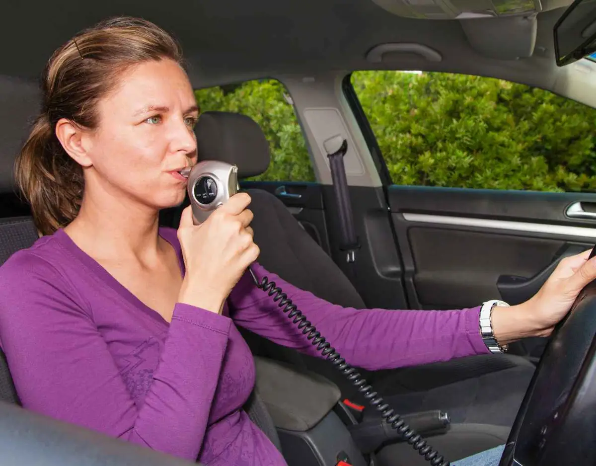 a woman blowing into a baiid to start a vehicle