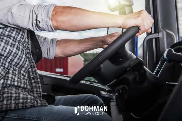 a truck driver's hands on the steering wheel