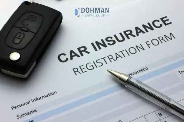 an insurance form on a table with a pen and car key fob