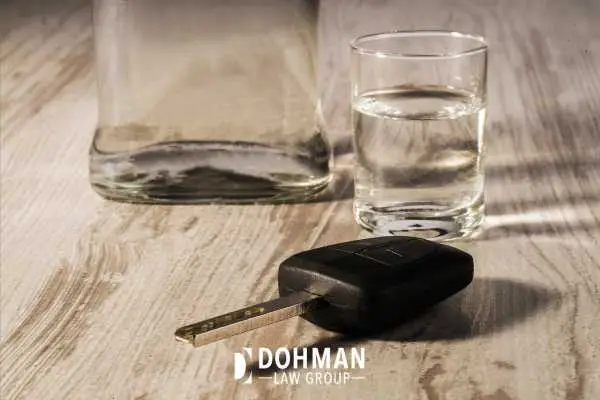alcohol in a glass and a car key on a table