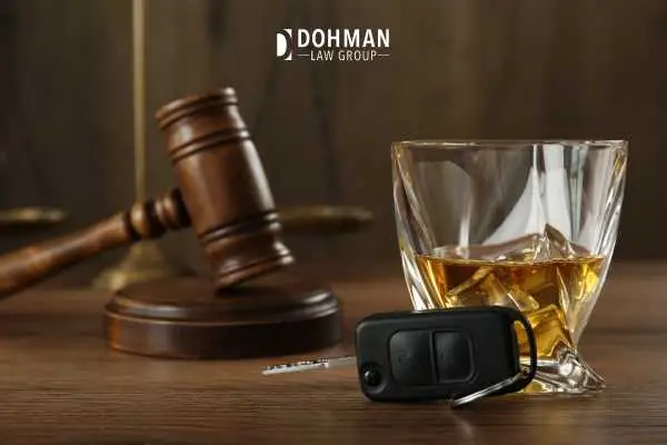 keys, whiskey, and a gavel on a desk