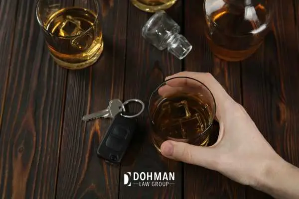 a man drinking with his car keys on the bar