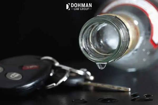 car keys and a bottle of alcohol in front of a black background