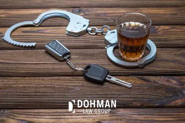 handcuffs, car keys, and a glass of alcohol on a table
