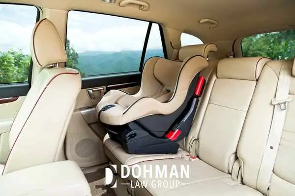 a photo of the interior of a car with a child's car seat in the back