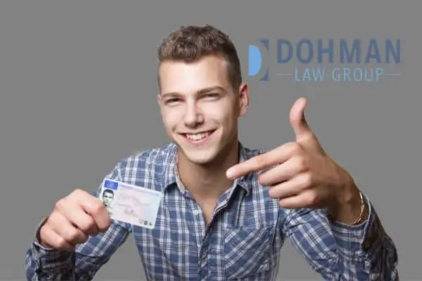 man smiling and pointing his driver's license