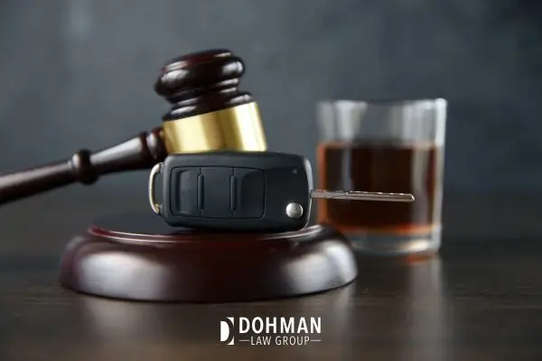 car key resting on gavel and alcohol in the background