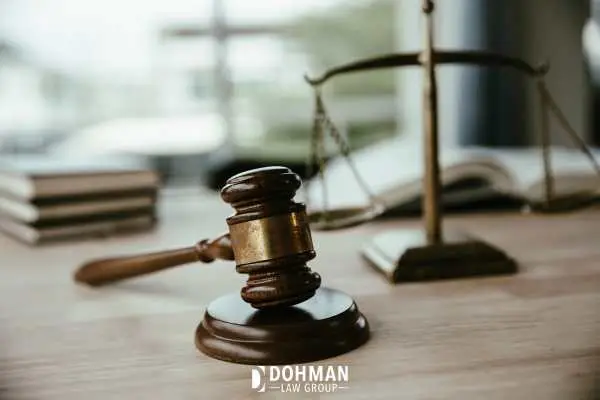 a judge's gavel and scale of justice on a wooden desk