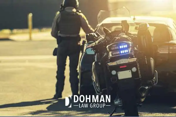 a police officer with a motorcycle pulling over a driver for suspected dui