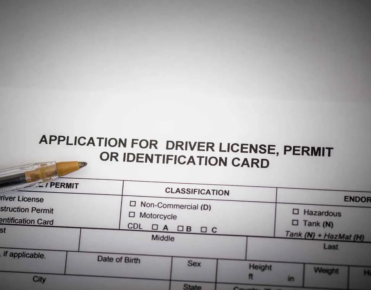 a drivers license application and pen