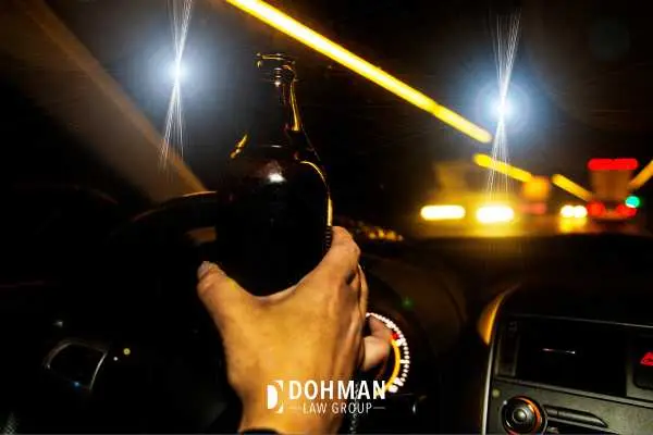a driver drinking a beer while behind the wheel