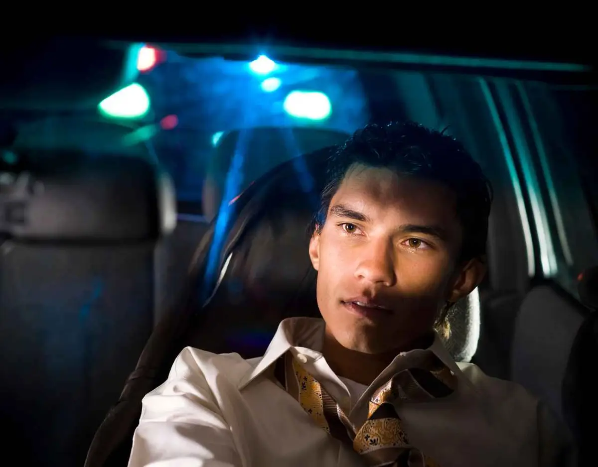 a man being pulled over at night for suspected drunk driving