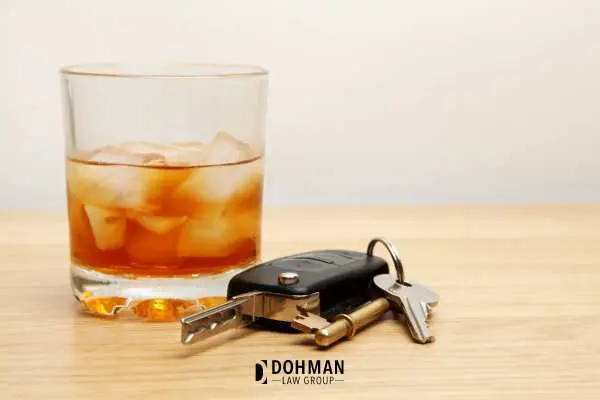 car keys and a glass of whiskey on a table
