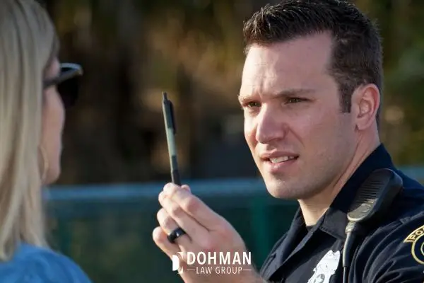 A police officer administering a sobriety test to a person.