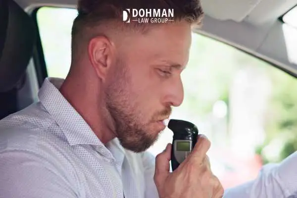 a man blowing into a BAIID to start his vehicle