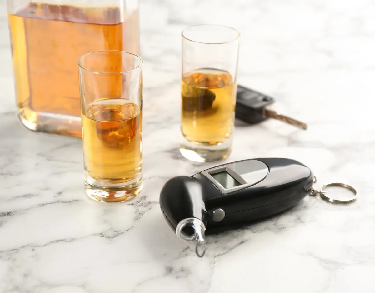 Shots of alcohol with a breathalyzer machine and car keys