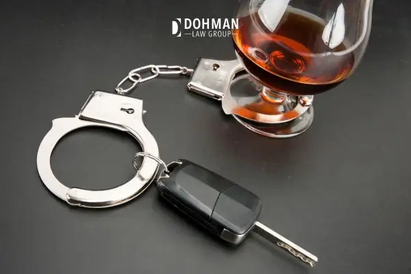 Car keys, glass of alcohol and hand cuffs.