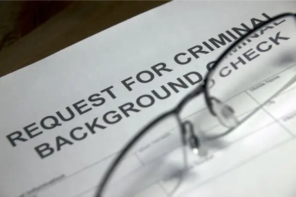 form for request for criminal background check with glasses laid on top