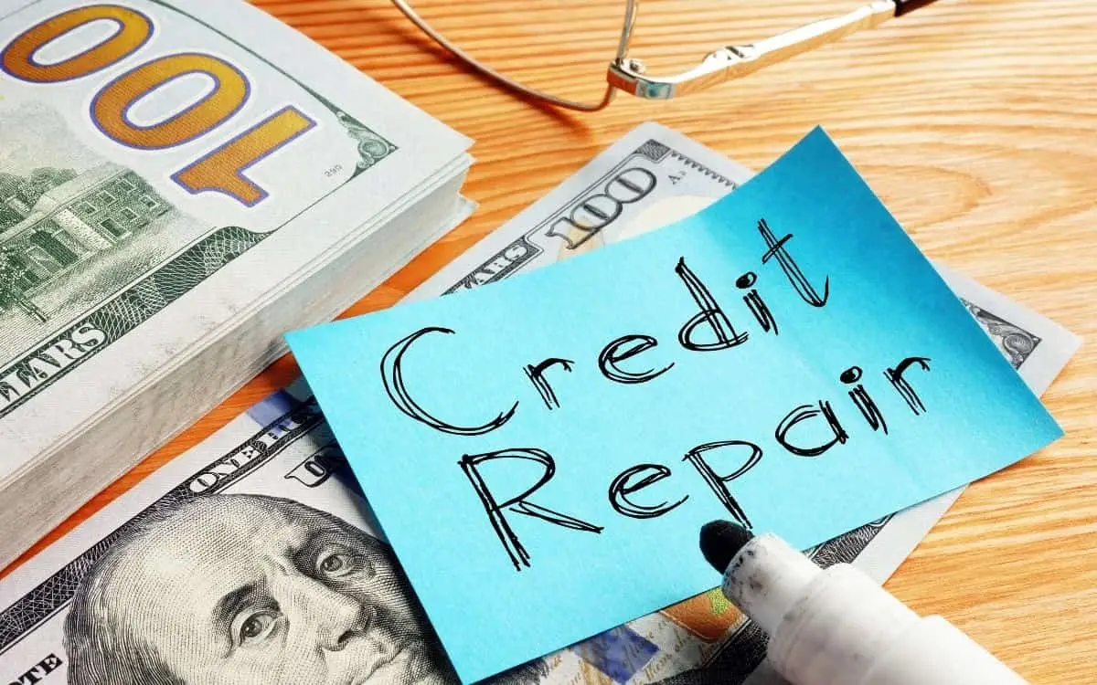 credit repair sticky note on top of 100 dollar bills