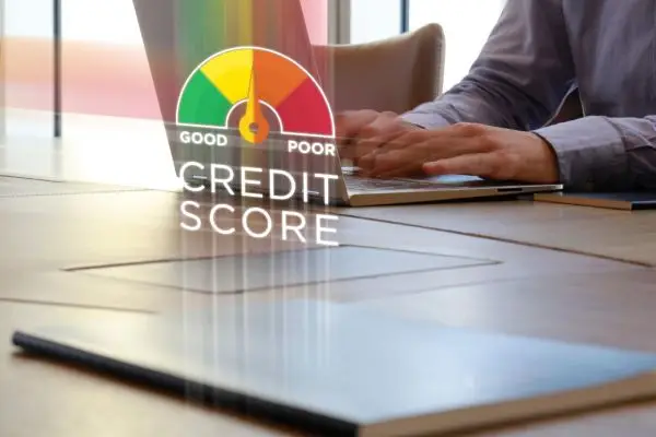 man on using laptop with a credit score graphic in front of him