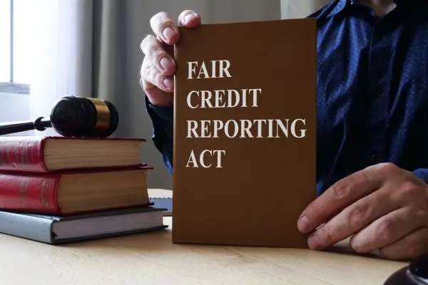 man holding up book with fair credit reporting act
