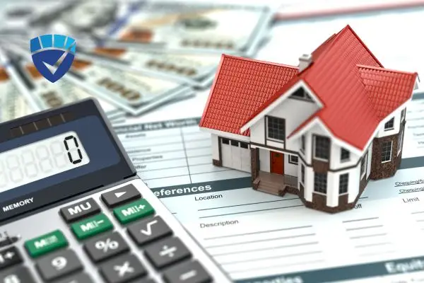 Calculator, money, and model house on financial documents.