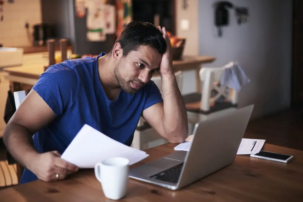 consumer looking at his credit score in his laptop concerned