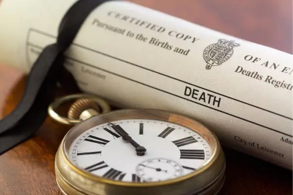death certificate rolled up next to pocket watch