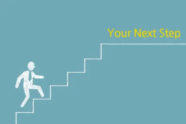A chalk drawing on blue shows a figure climbing stairs towards the yellow text "Your Next Step."