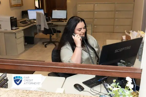 woman talking on the phone sitting at her desk in her office
