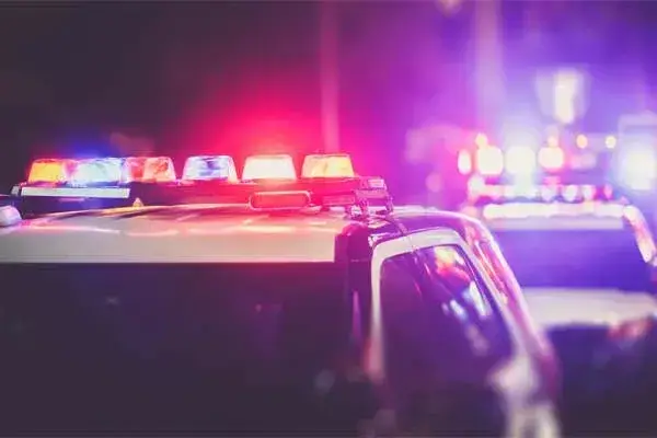 Two police patrol cars with the lights on