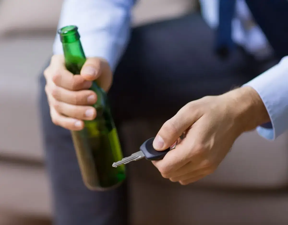 man holding a beer and his car keys